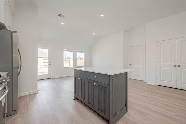 a kitchen with white cabinets and stainless steel appliances