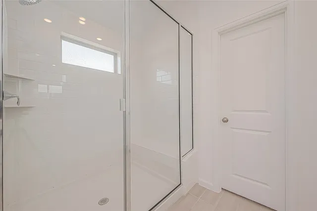 a bathroom with a shower and a glass door