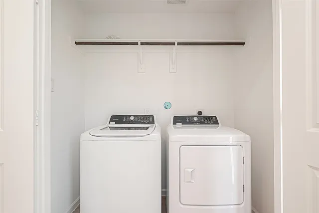 a view of washer and dryer with kitchen in the background