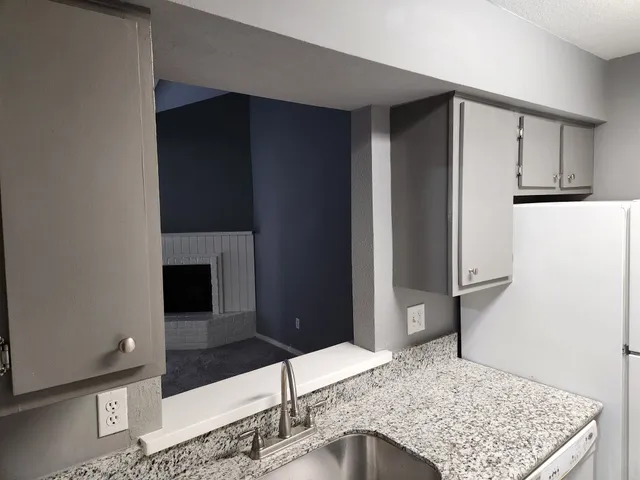 a view of a kitchen with refrigerator and wooden floor