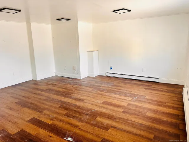 a view of empty room with wooden floor