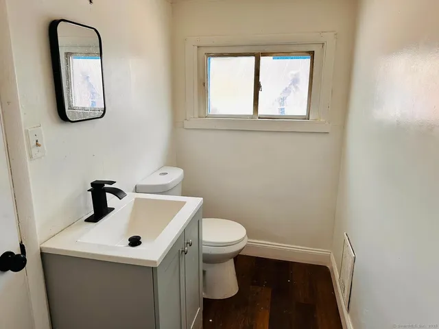 a bathroom with a toilet sink and mirror