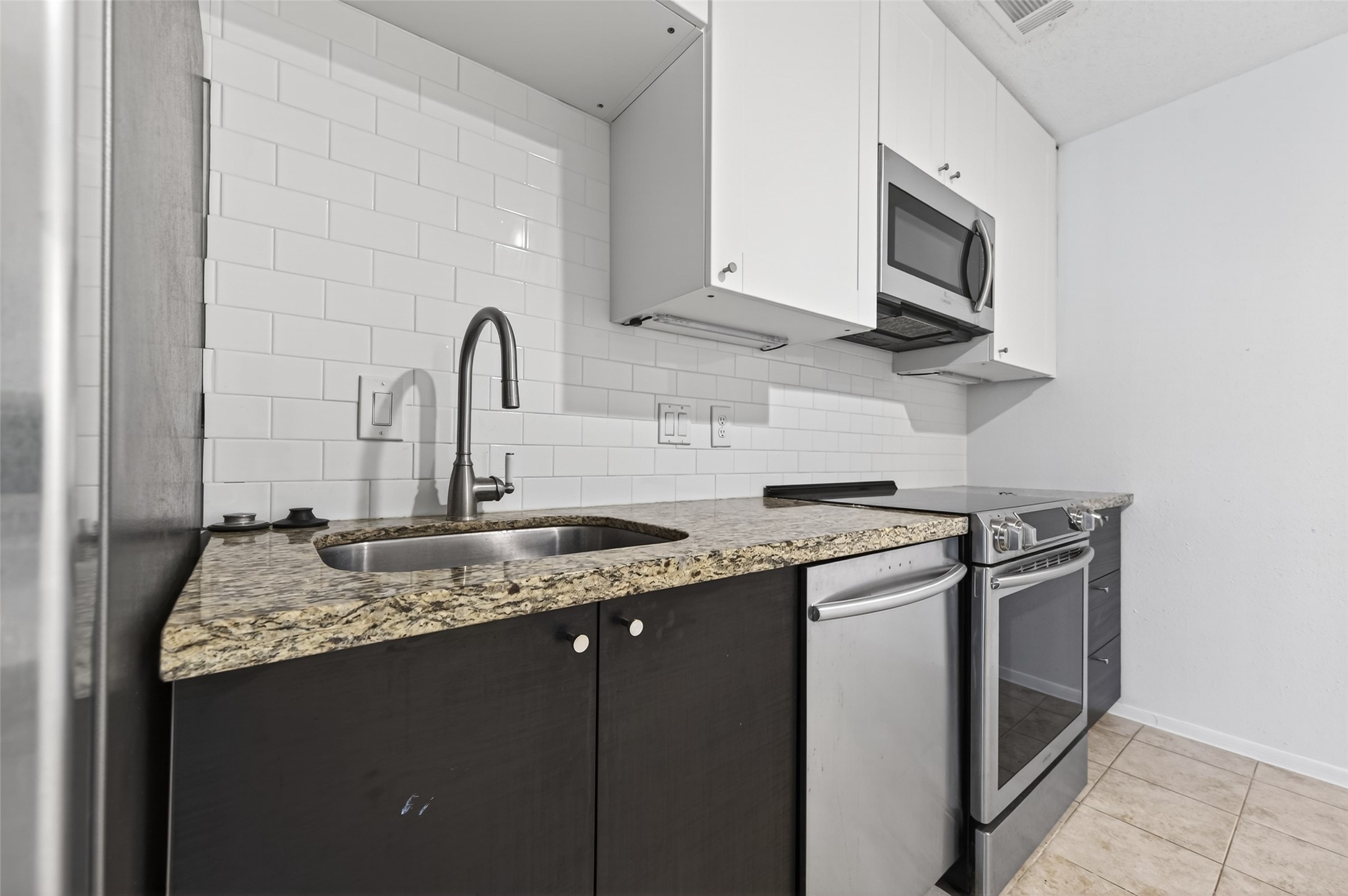 12900 Walden Road, Unit 108A Montgomery, TX 77356 - Photo 13 of 42 a kitchen with stainless steel appliances granite countertop a sink stove and microwave
