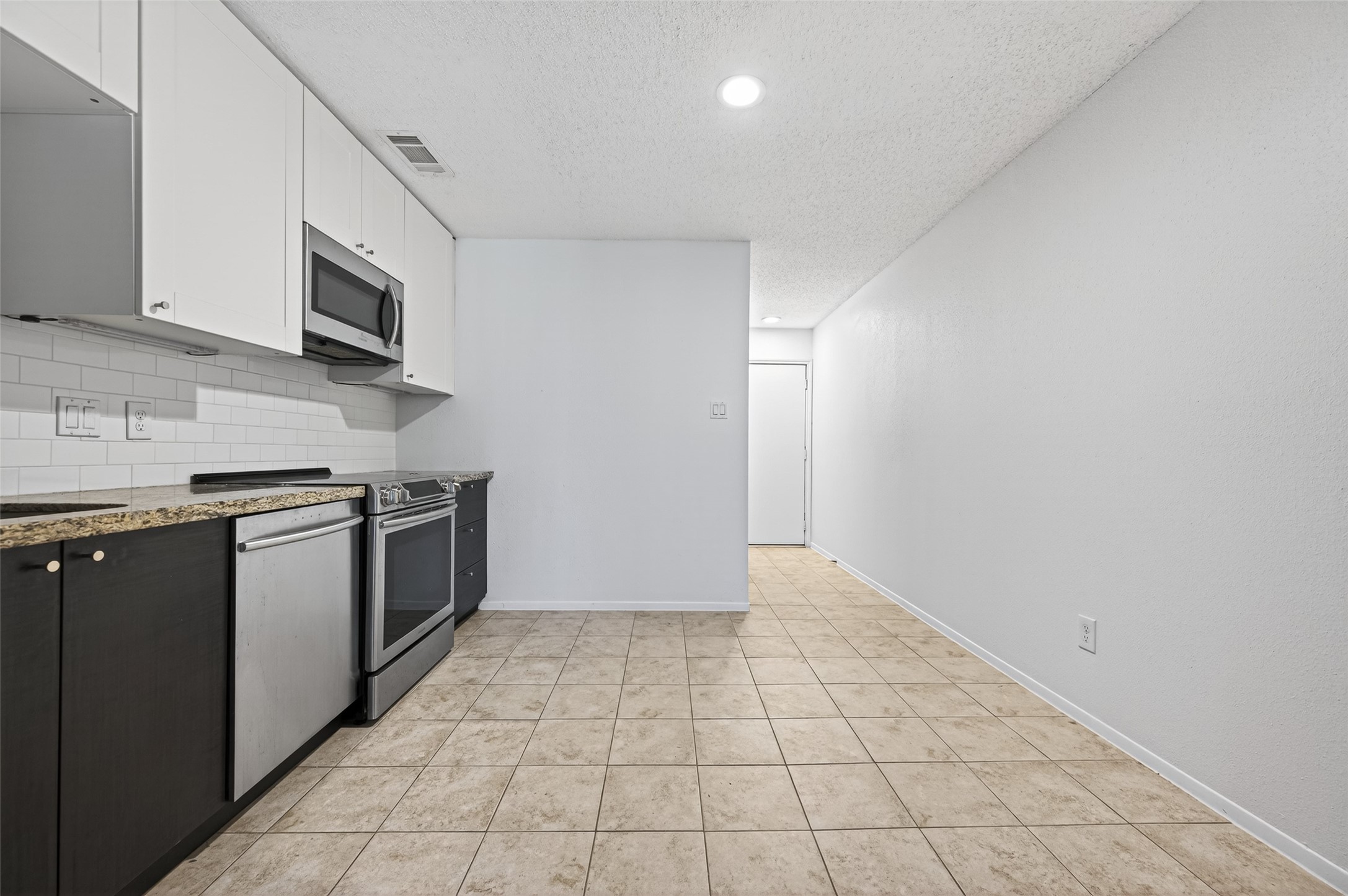 12900 Walden Road, Unit 108A Montgomery, TX 77356 - Photo 15 of 42 a kitchen with stainless steel appliances a sink a stove top oven a counter top space and cabinets