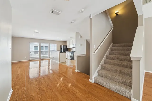 a view of a living room with wooden floor and staircase