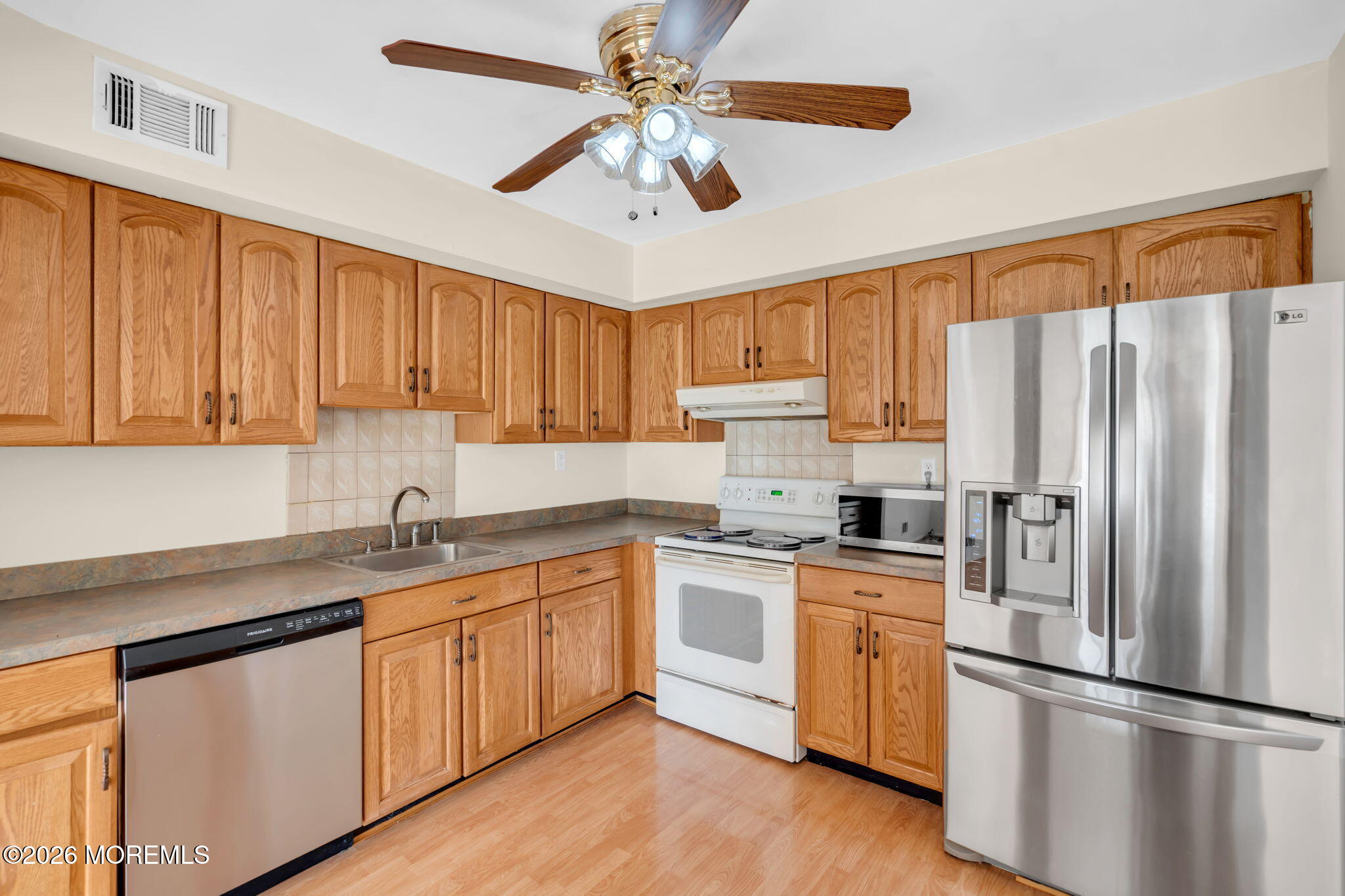 633 Randall Way Aberdeen, NJ 07747 - Photo 11 of 28 a kitchen with a sink a refrigerator a stove and cabinets
