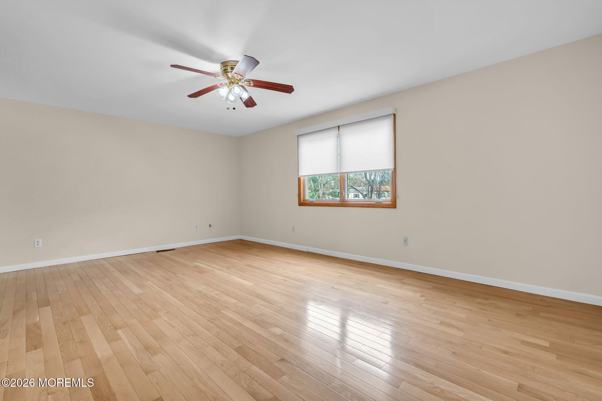 633 Randall Way Aberdeen, NJ 07747 - Photo 20 of 28 an empty room with wooden floor fan and windows