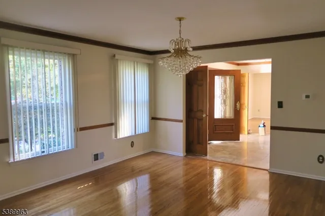a view of a room with wooden floor and a window
