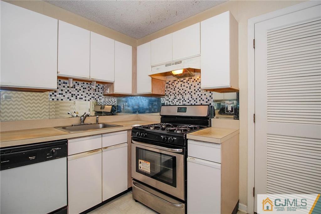 263 Prestwick Way, Unit 263 Edison, NJ 08820 - Photo 13 of 23 a kitchen with white cabinets and appliances