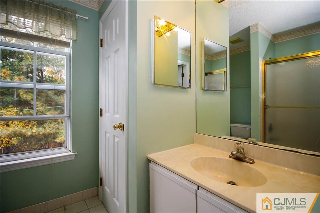 263 Prestwick Way, Unit 263 Edison, NJ 08820 - Photo 21 of 23 a bathroom with a sink and mirror with window