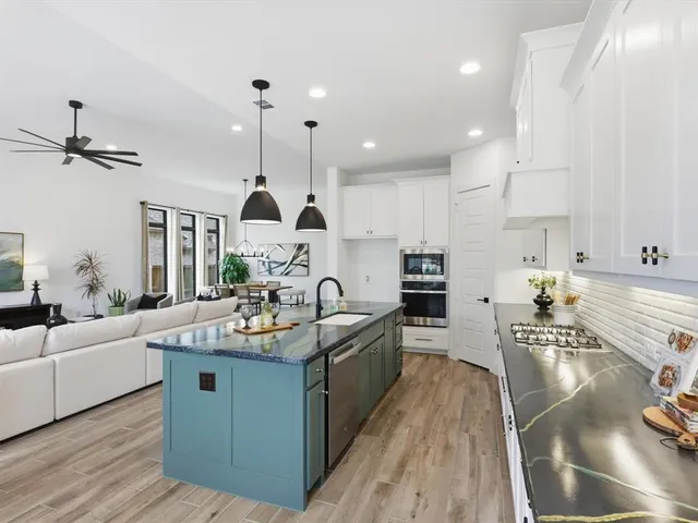 a kitchen with stainless steel appliances granite countertop a sink stove and refrigerator