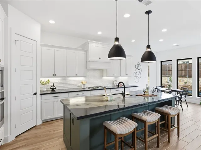 a kitchen with stainless steel appliances granite countertop a stove a sink and a refrigerator