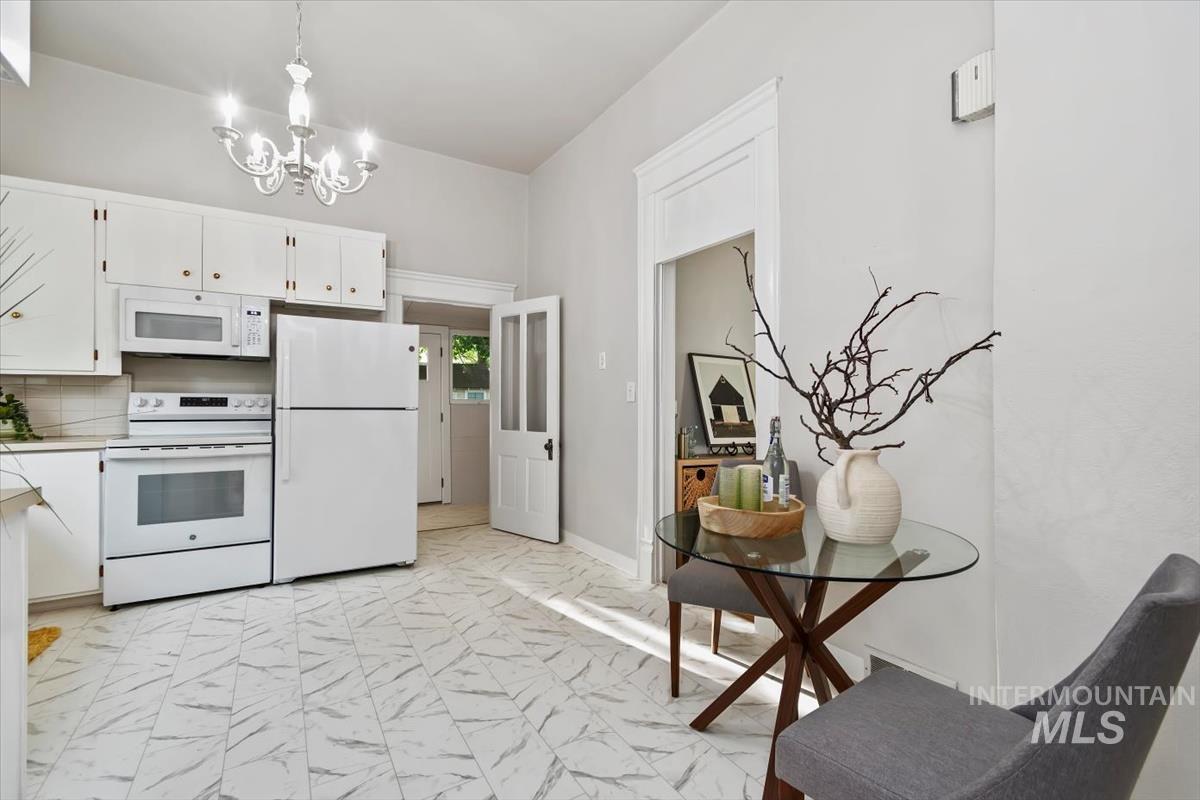 910 North 16th Street Boise, ID 83702 - Photo 21 of 47 Kitchen featuring white cabinetry, white appliance suite including a range, microwave, and refrigerator, and a chandelier light fixture