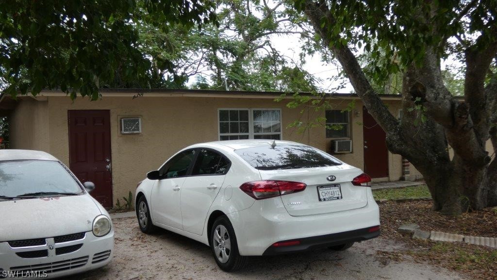4519 Luckett Road Fort Myers, FL 33905 - Photo 2 of 26 a white house covered with tall trees