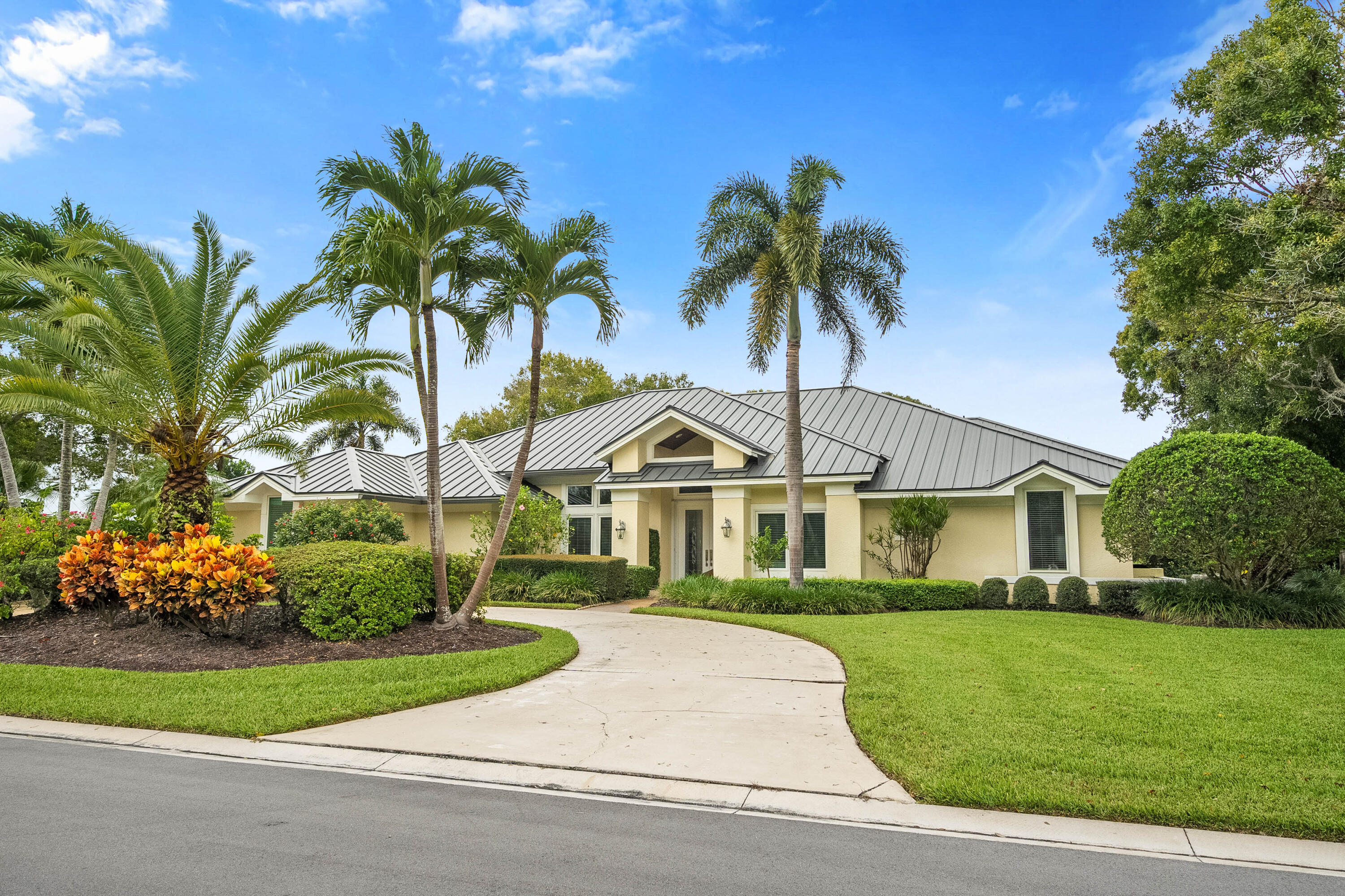 6217 Southeast Baltusrol Terrace Stuart, FL 34997 - Photo 4 of 69 a front view of a house with a garden and trees