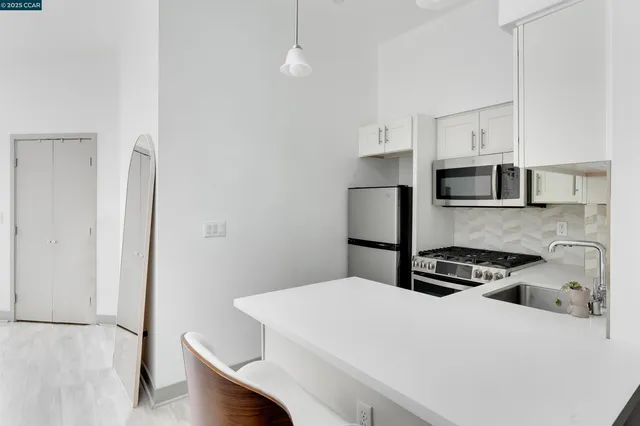 a kitchen with white cabinets and stainless steel appliances
