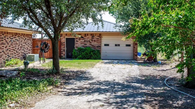 a patio with a table and chairs and potted plants