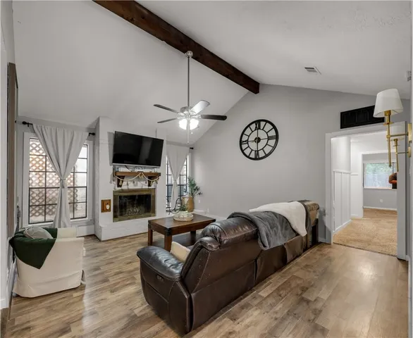 a living room with furniture a fireplace and a flat screen tv