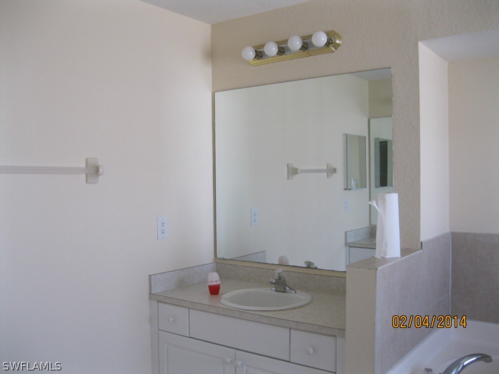 18225 Fuchsia Road Fort Myers, FL 33967 - Photo 15 of 23 a bathroom with a sink and a mirror