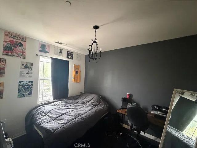 a bedroom with a bed dresser and a window