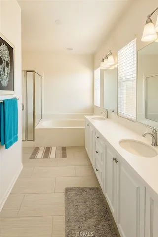 a spacious bathroom with a tub sink and a mirror