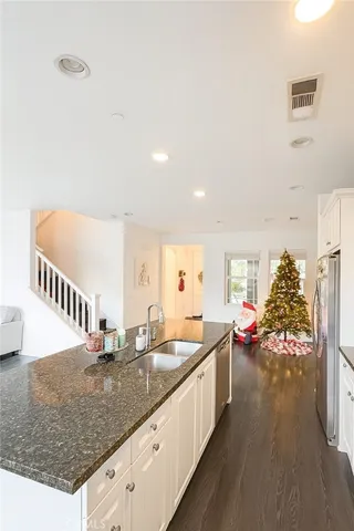 a kitchen with stainless steel appliances granite countertop a sink and a refrigerator