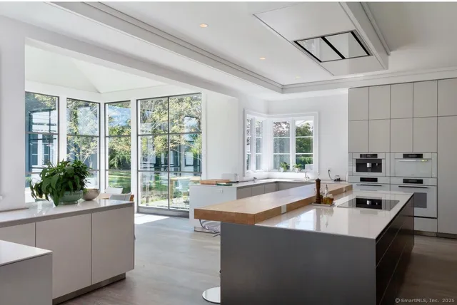 a large kitchen with kitchen island a large window in it