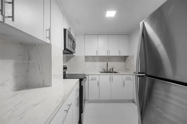 a kitchen with white cabinets and stainless steel appliances