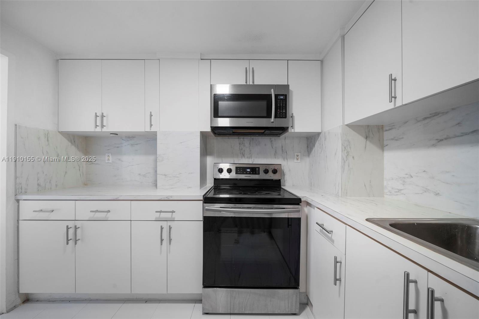 3301 Northeast 5th Avenue, Unit 214 Miami, FL 33137 - Photo 18 of 23 a kitchen with white cabinets and stainless steel appliances
