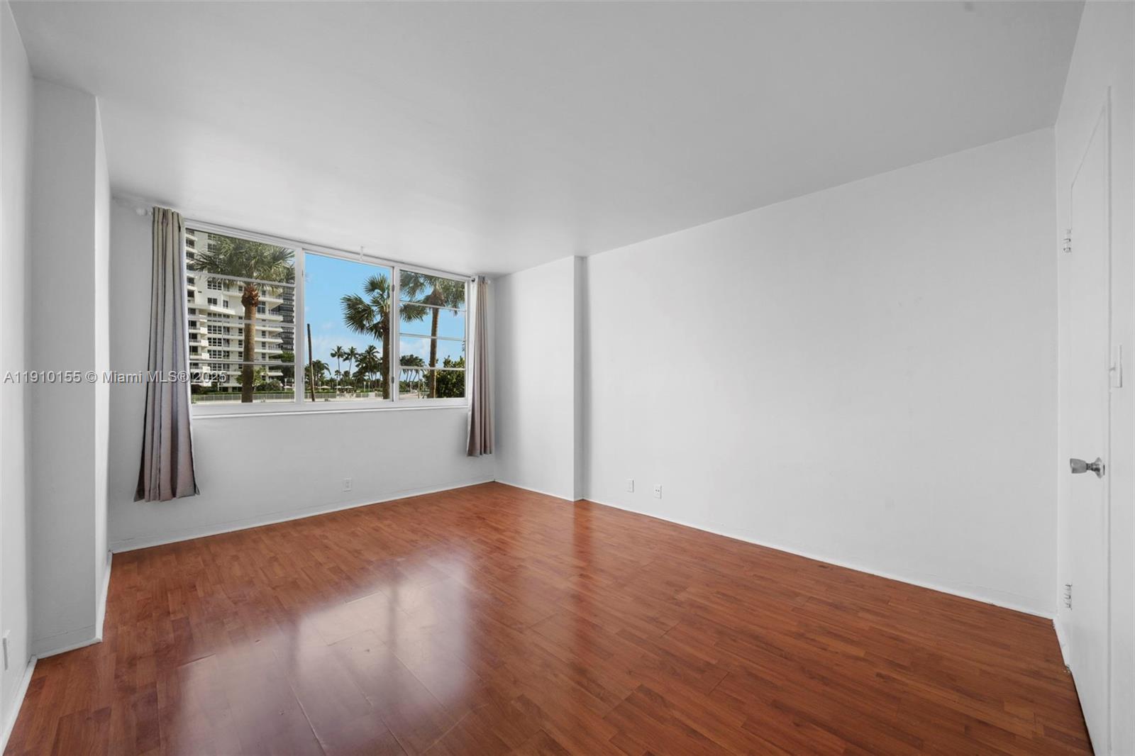 3301 Northeast 5th Avenue, Unit 214 Miami, FL 33137 - Photo 19 of 23 a view of an empty room with window and wooden floor