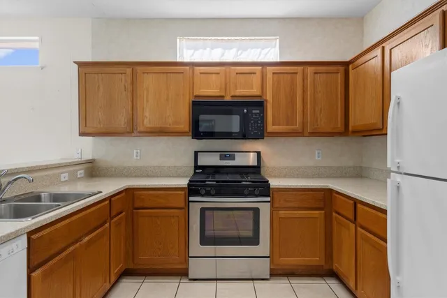 a kitchen with granite countertop a stove top oven microwave and cabinets