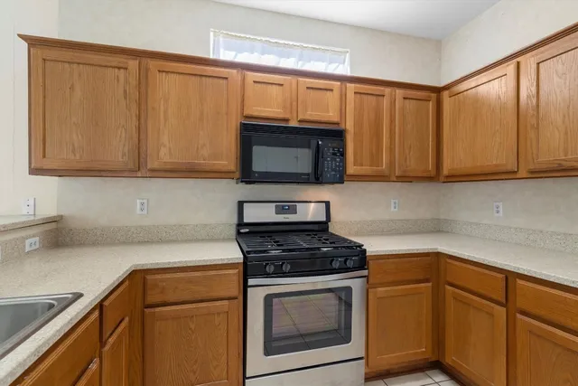 a kitchen with granite countertop cabinets stainless steel appliances and a sink