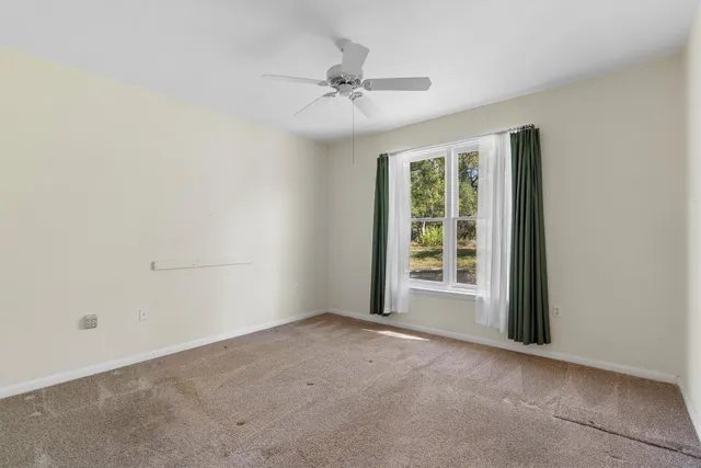 a view of a livingroom with a ceiling fan and window