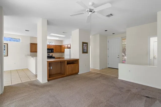 a view of a kitchen with refrigerator and a stove top oven