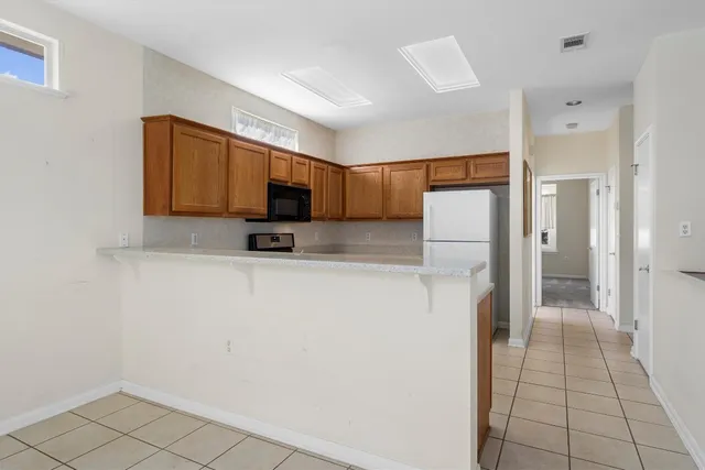 a kitchen with a refrigerator a microwave and cabinets