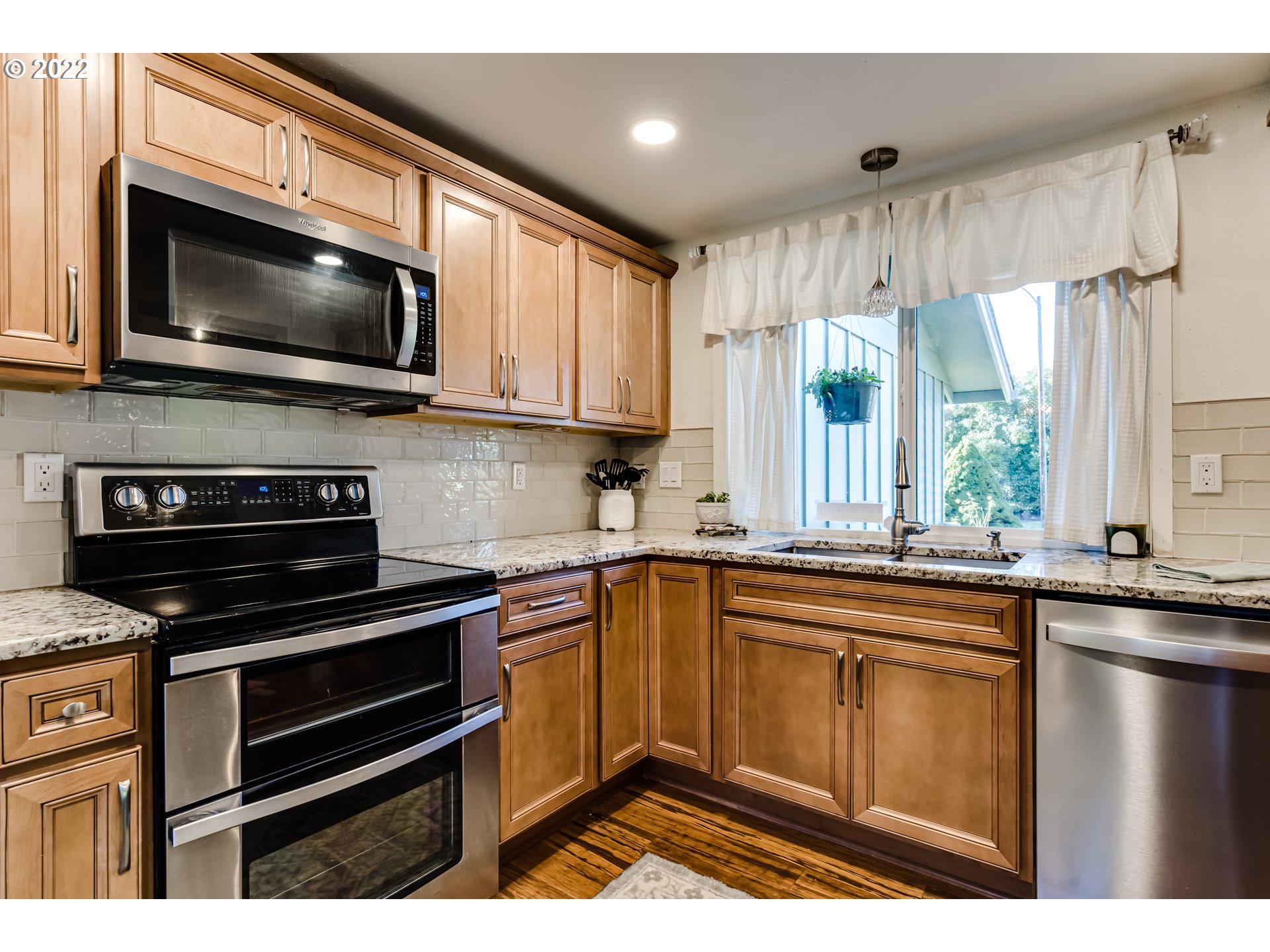 487 65th Street Springfield, OR 97478 - Photo 4 of 20 a kitchen with stainless steel appliances a stove sink microwave and cabinets