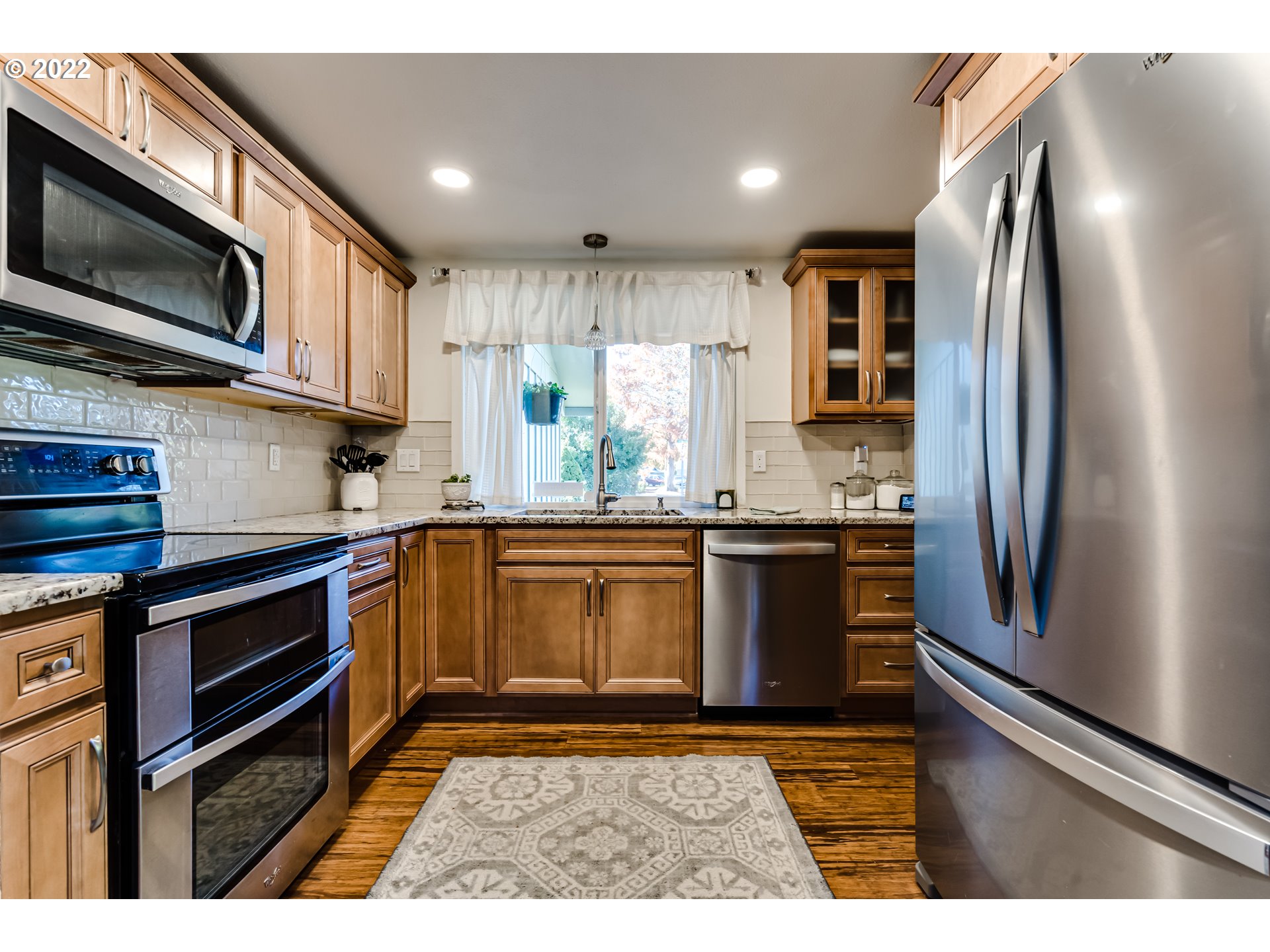 487 65th Street Springfield, OR 97478 - Photo 6 of 20 a kitchen with stainless steel appliances granite countertop a refrigerator a stove top oven a sink and dishwasher