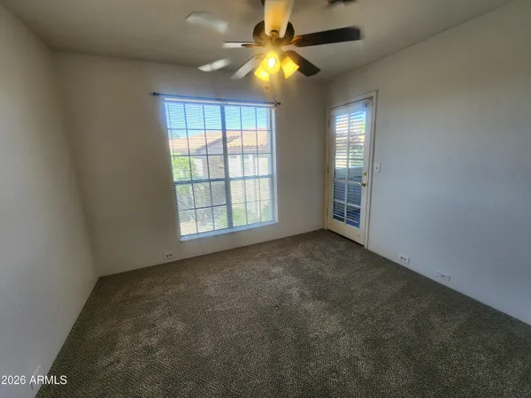 an empty room with windows and fan
