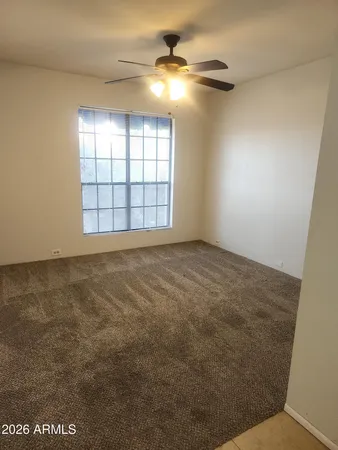 an empty room with windows and fan