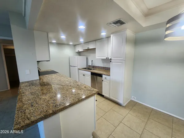 a spacious bathroom with a granite countertop sink and a mirror