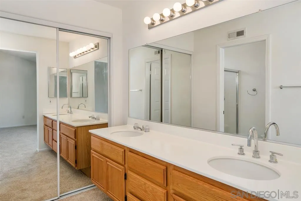 8727 Westmore Road, Unit 5 San Diego, CA 92126 - Photo 11 of 14 a bathroom with a sink double vanity granite tub shower and a mirror