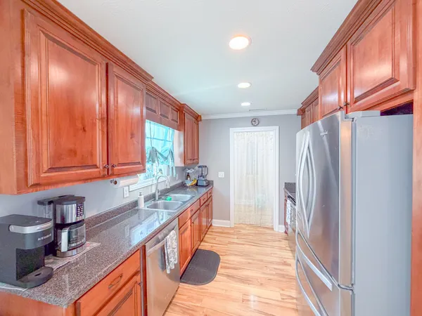 a kitchen with stainless steel appliances granite countertop a refrigerator and a sink