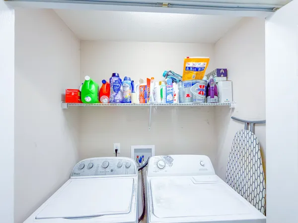 a utility room with dryer washer and shoe rack