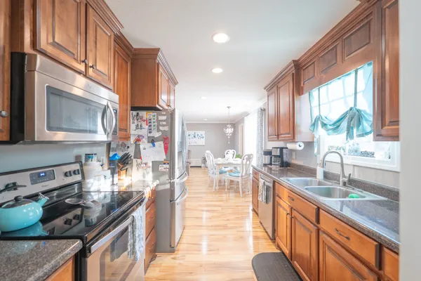 a kitchen with stainless steel appliances granite countertop sink stove top oven and cabinets