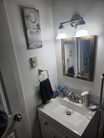 a bathroom with a sink vanity and mirror