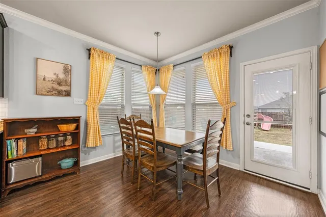 a kitchen with stainless steel appliances kitchen island granite countertop a stove a refrigerator a sink a dining table and chairs with wooden floor