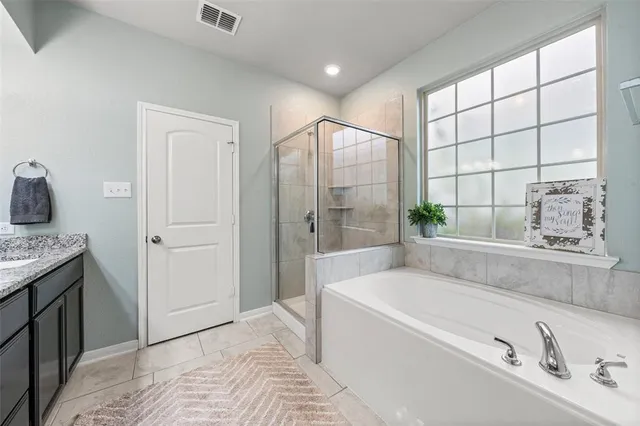 a spacious bedroom with a bed a dresser and a book shelf
