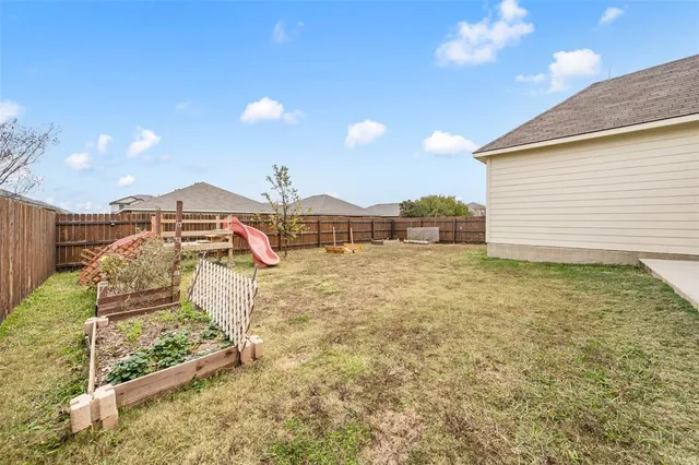 a view of an empty room with wooden floor and furniture