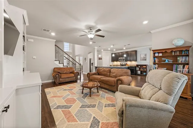a living room with furniture kitchen view and a chandelier