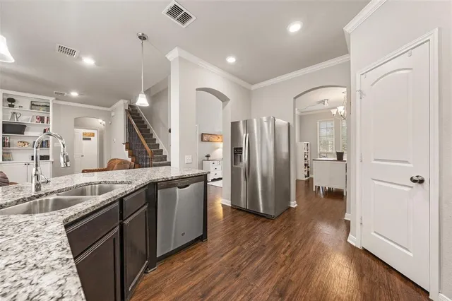 a large kitchen with a counter space a sink and stainless steel appliances